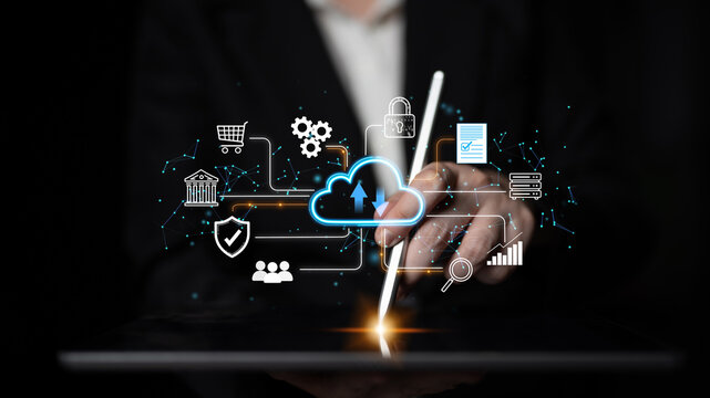 Business professional using digital tablet with cloud computing icons and data management symbols in a modern futuristic setting. Entropy.