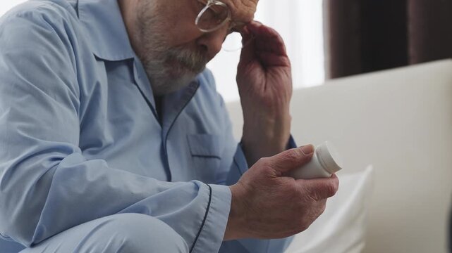 Senior man in eyeglasses reading supplement label, checking dosage instructions