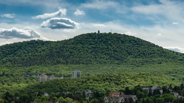 Budapest Janos Hill and Elizabeth Lookout time lapse over lush Buda Hills landscape with rushing clouds and rolling sunlight shadows