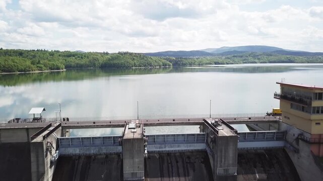 Shore of water reservoir with forest under blue sky at sunny summer day. Aerial view.