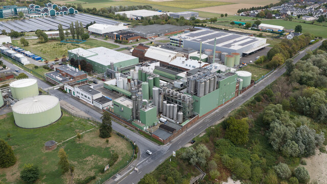 Monheim am Rhein, Germany - 04 September 2026: Aerial view of the UNIFERM GmbH Co. KG industrial site with large storage tanks, factory buildings, and surrounding green areas.
