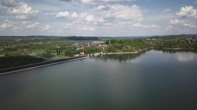 Shore of water reservoir with forest under blue sky at sunny summer day. Aerial view.