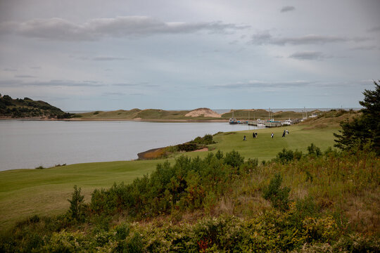 Inverness, Canada - September 18, 2026: Calm water and low coastal vegetation surround Inverness Harbour on the western shore of Cape Breton Island.