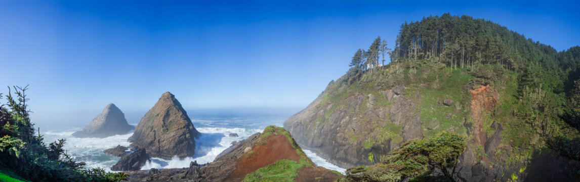 Beautiful wide panoramic view of a wild rocky ocean coast with green mountains and sea stacks at sunny day
