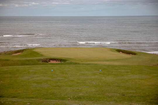 Inverness, Canada - September 18, 2026: Golf flag stands on a green overlooking the Gulf of St. Lawrence at Cabot Links
