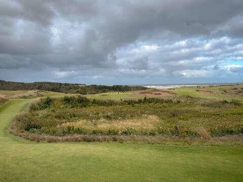 Inverness, Canada - September 18, 2026: Elevated teeing area overlooks rolling terrain, vegetation and water at Cabot Cliffs golf course.