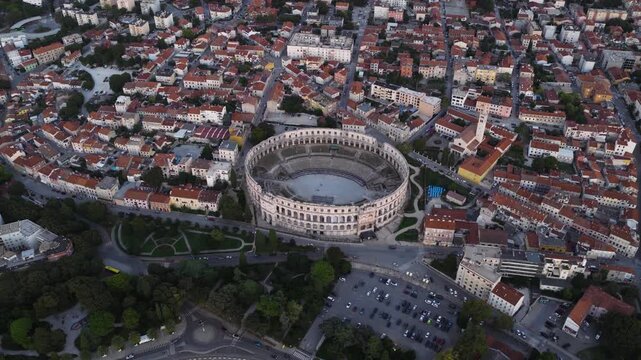 Aerial view of the historic Pula Arena surrounded by dense urban rooftops and streets in Pula, Istria County, Croatia.