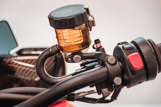 Motorcycle handlebar featuring a brake fluid reservoir and control buttons, highlighting engineering and safety technology details