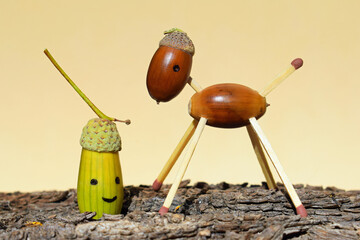 Animal figurine made of acorns and matches, with one painted smiling acorn. Autumn season © Martina
