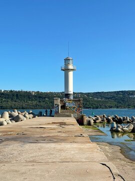 White Lighthouse on Concrete Pier Pierhead Under Clear Blue Sky