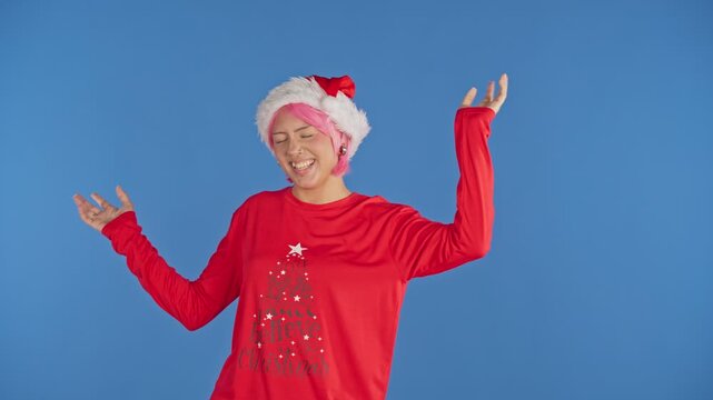 Joyful pink haired woman celebrating christmas while dancing
