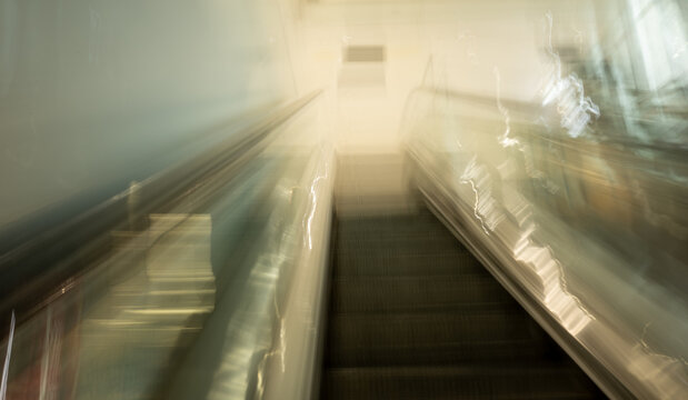 Intentional motion blur as moving up an escalator with light streaks
