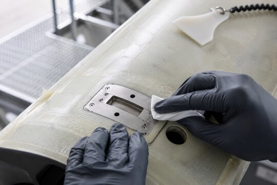 Wind turbine lightning protection inspection - hands cleaning a blade receptor