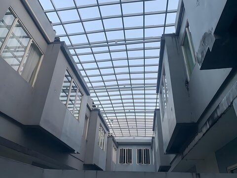 Low angle view of modern building interior showing a large glass skylight roof