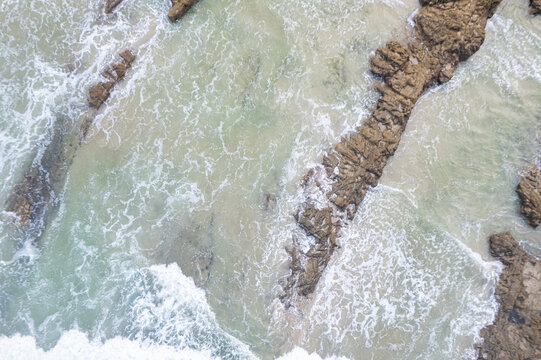 Aerial top down view of rocky reef and breaking sea waves The Concept of marine power