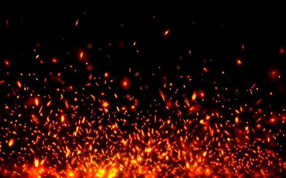 Intense burning fire embers and hot sparks rising into the dark night air with fire particles glowing cinders firefly effect flame embers