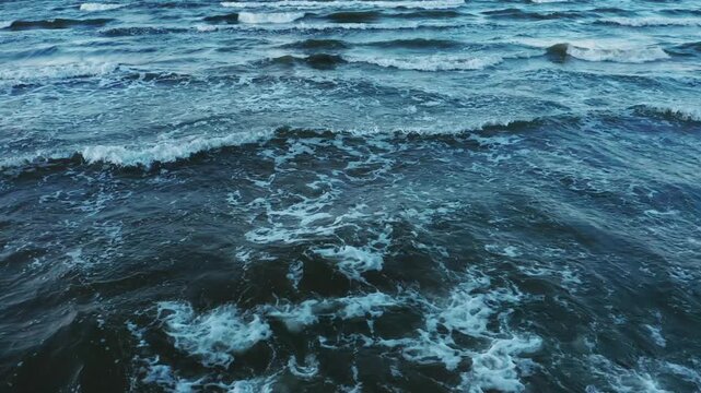 Big sea waves spindrift very close up. fly low over waves. Drone view above Jurmala marine beach presents somber scene winter. 4k Aerial view Baltic sea ice at sunset waves. Latvian resort. Lithuania