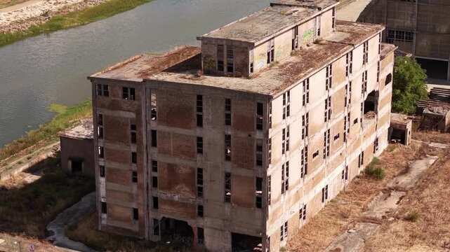 Close aerial view of derelict industrial building with concrete facade