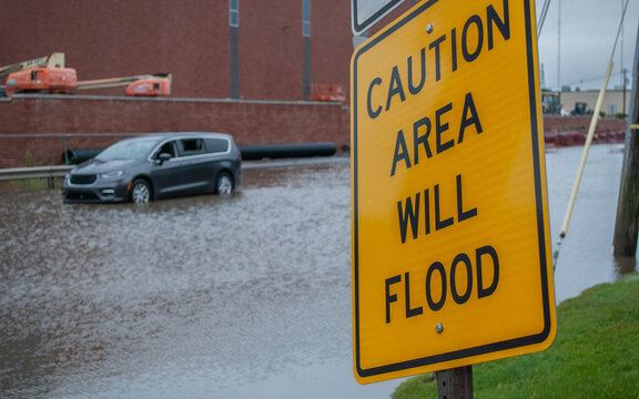 Yellow Caution Flood Warning Sign on Flooded Street