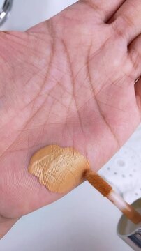 Point of view applying a small amount of cushion foundation on palm. Makeup swatch test, beauty product trial concept.