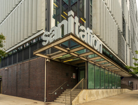 New York, NY - US - Sep 25, 2026 : NYC Department of Sanitation Manhattan Districts 1-2-5 Garage entrance in Hudson Square features large sanitation lettering, metal fins, brick walls and glass walls.