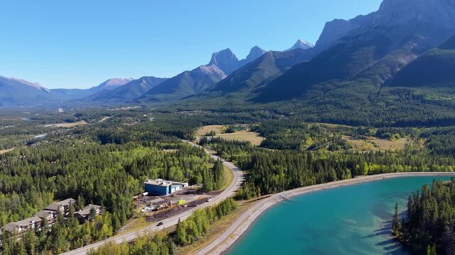 Canmore Rundle Forebay and Highway 742 Spray Lakes Road through autumn pine forest and mountains aerial view. Canmore, Alberta, Canada.
