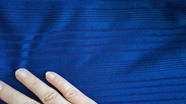 A hand strokes the cozy blue fabric.