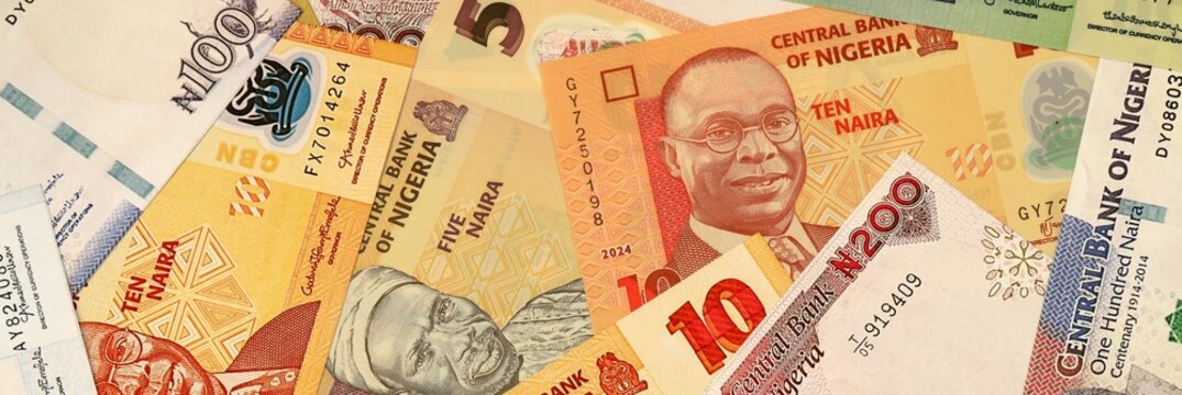 Nigerian naira money bills in pile on table. Nigeria NGN currency cash close up