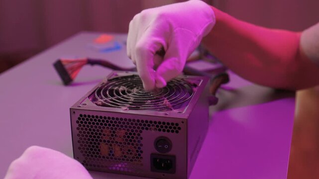 Technician cleaning computer. Expert cleaning and examining computer hardware meticulously. Technician carefully clearing dust from open computer with specialized tools