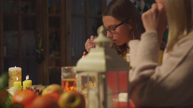Friends drink warm red beverages while sharing a calm seasonal evening during the holiday season. Medium portrait view presents winter comfort with strong commercial appeal.