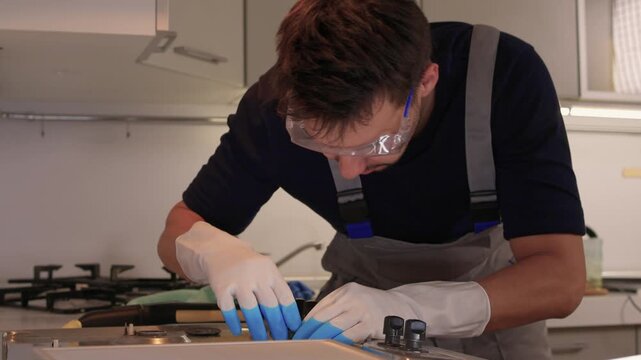 Professional technician ensures proper cleaning and safety measures. Trained technician performs detailed cleaning while maintaining safety in modern kitchen environment