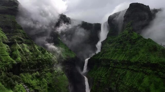 Stunning waterfall cascading down lush green misty mountains in the western ghats, india