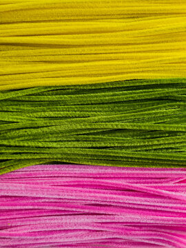 Colorful fuzzy pipe cleaner texture, yellow green pink fluffy background