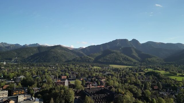Zakopane - Polska
Widok na kości&oacute;ł, Tatry, Giewont nagrany dronem w słoneczny dzień. Piękne widoki g&oacute;rskie nagrane z powietrza w stolicy Podhala