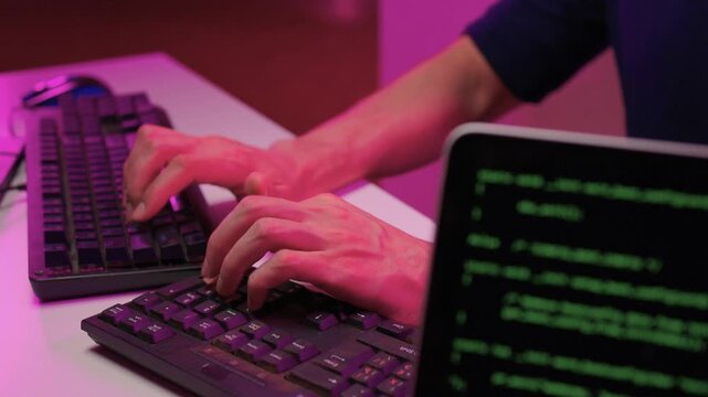 Focused coding session. Hands dash across keys with vibrant illumination. Intense keyboard action with RGB lighting highlighting dedicated programming night activities