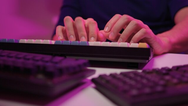 Focused coding session. Hands dash across keys with vibrant illumination. Intense keyboard action with RGB lighting highlighting dedicated programming night activities