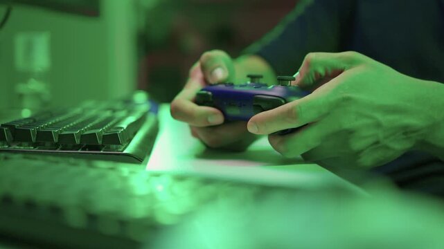 Gamer gripping red controller in dark hoodie, lowlit room with neon green PC and blurred monitor, closeup on hands and controller, tense focused mood, latenight stream atmosphere