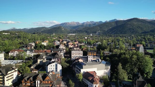 Zakopane - Polska
Widok na kości&oacute;ł, Tatry, Giewont nagrany dronem w słoneczny dzień. Piękne widoki g&oacute;rskie nagrane z powietrza w stolicy Podhala