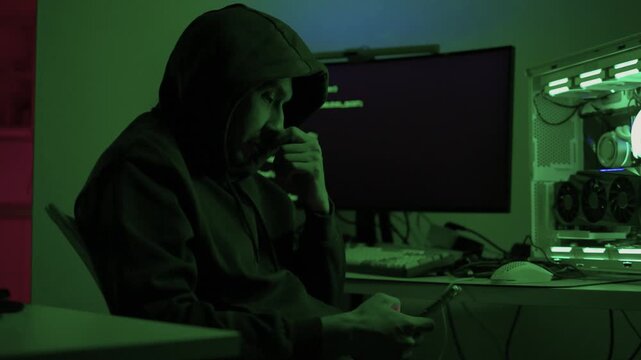 Solo software engineer working through technical issues late at night. Dedicated coder in dim lighting diagnosing problems on open computer case with intense concentration