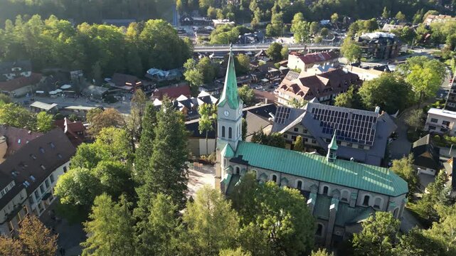 Zakopane - Polska
Widok na kości&oacute;ł, Tatry, Giewont nagrany dronem w słoneczny dzień. Piękne widoki g&oacute;rskie nagrane z powietrza w stolicy Podhala