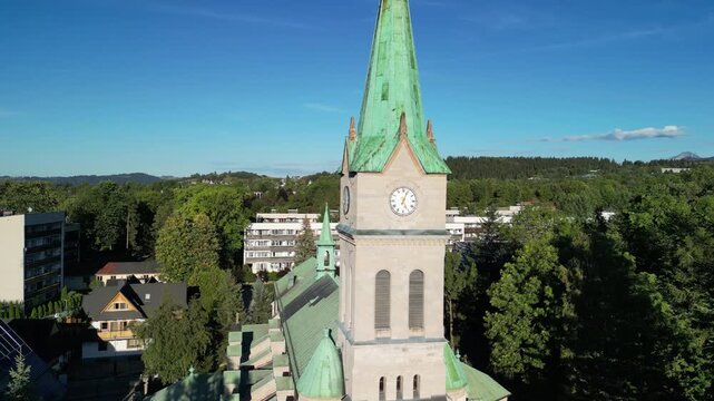 Zakopane - Polska
Widok na kości&oacute;ł, Tatry, Giewont nagrany dronem w słoneczny dzień. Piękne widoki g&oacute;rskie nagrane z powietrza w stolicy Podhala