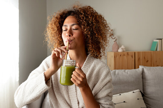 Woman drinking green smoothie for healthy morning lifestyle