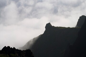 Volcanic ridge silhouette above drifting clouds © Andrei