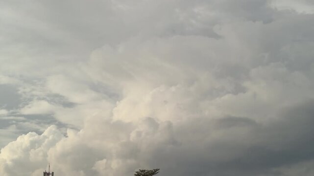 Blue sky with white clouds and the sun. Fast-moving white and gray clouds. Time-lapse photograph of cumulus clouds. Nature time-lapse video in the rainy season. Weather. Sky. Nature.