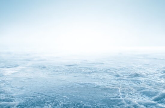 A bright, frosty, scratched ice surface extends into a soft blue, hazy horizon