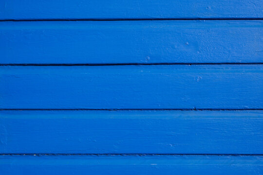 Bright blue painted wood texture with wide horizontal boards and visible grain
