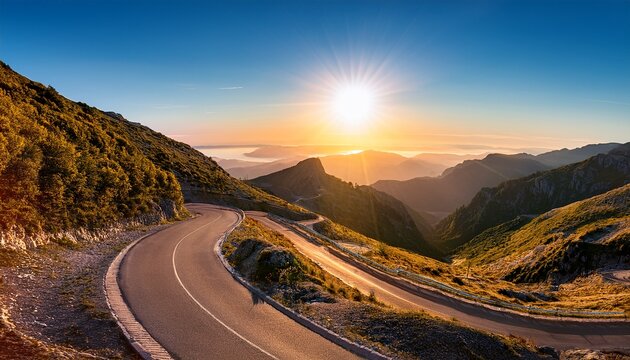 winding mountain road with scenic views of the sun and surrounding landscape
