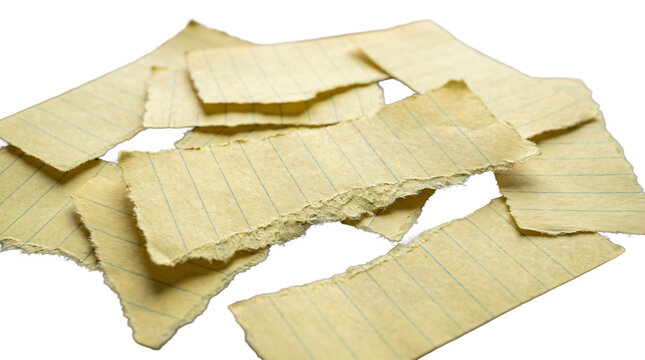 A messy pile of old torn lined paper pieces sits isolated on a transparent studio backdrop.