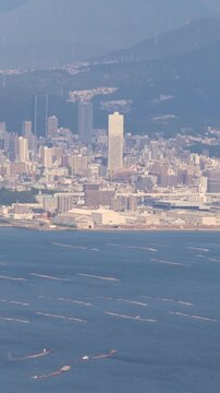 Hiroshima City aerial panoramic view seen from Mount Misen on Miyajima Island, with Seto Inland Sea, Hiroshuma bay and skyline, port and oyster farming rafts, Chugoku, Japan, mountains in background