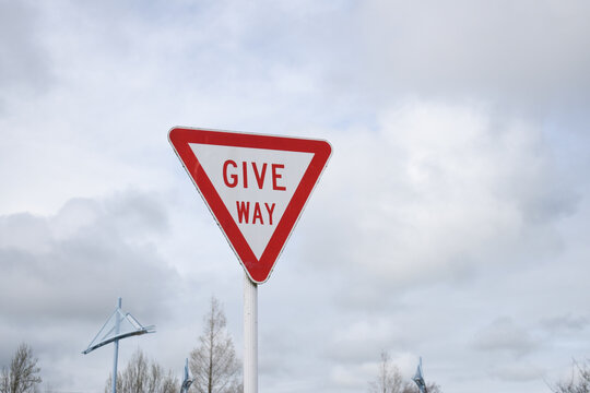 Triangle give way sign against a cloudy blue sky